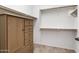 Spacious walk-in closet with custom shelves, hanging rods and built-in wood cabinet at 42335 W Waterfall Way, Maricopa, AZ 85138