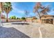 Wide backyard featuring gravel landscaping, mature trees, and a privacy fence at 44314 W Mescal St, Maricopa, AZ 85138