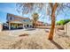 Large, private backyard with gravel landscaping, mature trees, and covered patio at 44314 W Mescal St, Maricopa, AZ 85138