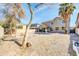 Spacious backyard with desert landscaping, mature trees, and covered patio area at 44314 W Mescal St, Maricopa, AZ 85138