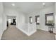 Bright upstairs hallway featuring neutral carpet, white railing, and two windows at 44314 W Mescal St, Maricopa, AZ 85138