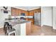 Well-lit kitchen featuring stainless steel appliances, dark countertops and wood cabinetry at 44314 W Mescal St, Maricopa, AZ 85138