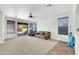 Bright living room with carpet, ceiling fan, and sliding glass door leading to a patio at 44314 W Mescal St, Maricopa, AZ 85138