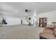 Expansive living room featuring neutral carpet, staircase, and ample space for entertaining at 44314 W Mescal St, Maricopa, AZ 85138