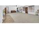 Large living room with neutral carpet, built-in shelving, and plenty of room for furniture and activities at 44314 W Mescal St, Maricopa, AZ 85138