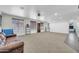 Spacious living room with neutral carpet, ceiling fan, and plenty of natural light from large windows at 44314 W Mescal St, Maricopa, AZ 85138