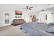 Large bedroom with ensuite bathroom, leather sofa, and ceiling fan at 44314 W Mescal St, Maricopa, AZ 85138