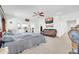 Large bedroom featuring a ceiling fan, leather sofa, and an ensuite bathroom at 44314 W Mescal St, Maricopa, AZ 85138