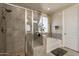 Beautiful bathroom featuring a bathtub, glass-enclosed shower, and a window with stylish curtains at 5012 S Girard St, Gilbert, AZ 85298