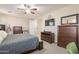 Comfortable main bedroom showcases wood furniture, a ceiling fan, and access to the ensuite bathroom at 5012 S Girard St, Gilbert, AZ 85298