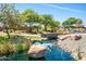 Picturesque water feature with stone bridge nestled in lush landscaping with mature trees at 5012 S Girard St, Gilbert, AZ 85298
