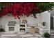 Charming backyard with a built-in grill, seating area, and beautiful red flowers at 5101 N Casa Blanca Dr # 223, Paradise Valley, AZ 85253