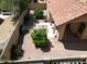 Aerial view of a private backyard with mature trees, low-maintenance desert landscaping, and a covered patio at 563 N Spanish Springs Dr, Chandler, AZ 85226