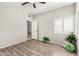 Cozy bedroom features wood-look flooring, a ceiling fan, and plantation shutters for natural light at 563 N Spanish Springs Dr, Chandler, AZ 85226