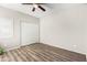 Cozy bedroom features wood-look flooring, a ceiling fan, a window, and a double door closet at 563 N Spanish Springs Dr, Chandler, AZ 85226