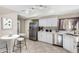 Well-lit kitchen features white cabinets, stainless steel appliances, and granite countertops, complementing the tile flooring at 563 N Spanish Springs Dr, Chandler, AZ 85226