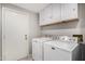 Functional laundry room featuring a washer, dryer, and cabinets for storage at 563 N Spanish Springs Dr, Chandler, AZ 85226