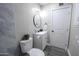 Bathroom showcasing a modern vanity, round mirror, and toilet with decorative plant accents at 6130 N 27Th Ave, Phoenix, AZ 85017