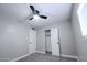 Bedroom with gray walls, carpeted floors, a fan, a closet with open doors, and a white door at 6130 N 27Th Ave, Phoenix, AZ 85017