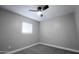 This is a view of a bedroom with a window and a fan with gray walls and carpeted floors at 6130 N 27Th Ave, Phoenix, AZ 85017