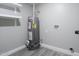 This is a utility room with gray walls, a water heater, white shelves, and gray flooring at 6130 N 27Th Ave, Phoenix, AZ 85017