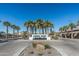 View of the Palma Brisa entrance with palm trees, landscaping, and blue signage at 634 E Deer Creek Rd, Phoenix, AZ 85048
