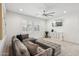 Bright living room with a large sectional, neutral carpet, and a modern ceiling fan at 634 E Deer Creek Rd, Phoenix, AZ 85048