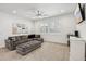 Bright living room with a large sectional, neutral carpet, and a modern ceiling fan at 634 E Deer Creek Rd, Phoenix, AZ 85048