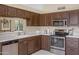Bright kitchen with stainless appliances, wooden cabinets, and a pass-through to the dining room at 6341 S Cypress Point Dr, Chandler, AZ 85249