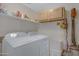 Functional laundry room with white washer and dryer, storage shelves, and cleaning supplies at 6341 S Cypress Point Dr, Chandler, AZ 85249