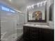 Bathroom featuring double sinks, granite counters, tiled shower with glass door, and natural light at 650 N Hawes Rd # 3123, Mesa, AZ 85207