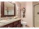 Bathroom with granite countertop vanity, framed mirror, and glass-enclosed shower at 7103 E Medina Ave, Mesa, AZ 85209
