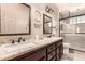 Modern bathroom features dual vanities, granite countertops, and a walk-in shower with glass door at 7103 E Medina Ave, Mesa, AZ 85209