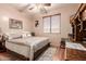 Cozy bedroom with light-colored walls, ceiling fan, and natural wood flooring at 7103 E Medina Ave, Mesa, AZ 85209