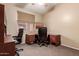 This home office features a dark desk set and chairs, perfect for working from home at 7103 E Medina Ave, Mesa, AZ 85209