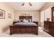 This comfortable main bedroom features a dark wood frame bed, side tables and dresser at 7103 E Medina Ave, Mesa, AZ 85209