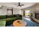 Bright living room with a stone fireplace, a green sectional, and sliding glass doors to the outside at 7129 E Broadway Rd # 72, Mesa, AZ 85208