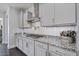 Bright kitchen with white cabinets, granite counters, stainless steel range hood, and modern backsplash at 7149 E Plata Ave, Mesa, AZ 85212
