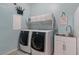 Laundry room with front loading machines, utility sink, and overhead storage at 7149 E Plata Ave, Mesa, AZ 85212
