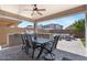 A covered outdoor kitchen features a built-in grill, a table with seating, and comfortable outdoor furniture at 7149 E Plata Ave, Mesa, AZ 85212