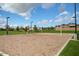 A sand volleyball court is surrounded by green grass, showcasing the park's recreational options at 7149 E Plata Ave, Mesa, AZ 85212