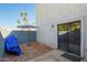 Small gravel backyard with stucco wall, palm trees, an umbrella and a sliding glass door at 7506 N 47Th Dr, Glendale, AZ 85301