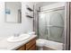 Bright bathroom with a vanity, toilet, mirror, shelves, and shower with sliding doors at 7506 N 47Th Dr, Glendale, AZ 85301