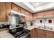 Kitchen with black stove top, light countertops, and raised-panel wood cabinetry at 7506 N 47Th Dr, Glendale, AZ 85301