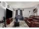 Inviting living room featuring a plush brown leather sofa and neutral tile flooring at 7506 N 47Th Dr, Glendale, AZ 85301