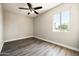 Neutral bedroom with wood-look floors, ceiling fan, and a large window for natural light at 7920 E Camelback Rd # 110, Scottsdale, AZ 85251