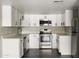 Updated kitchen featuring white cabinets, stainless steel appliances and gray wood flooring at 7920 E Camelback Rd # 110, Scottsdale, AZ 85251