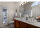 Bathroom with double sinks, stained glass door, tile floor, and a large mirror at 7940 W Taro Ln, Glendale, AZ 85308