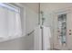 Modern bathroom features glass shower door, white tile, window, and a towel rack at 7940 W Taro Ln, Glendale, AZ 85308