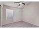 Bedroom with large window and ceiling fan with lights at 7940 W Taro Ln, Glendale, AZ 85308